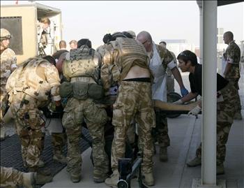جنود بريطانيون ينقلون زميلاً لهم أصيب في الهجوم إلى مستشفى عسكري في هلمند في جنوب أفغانستان أمس