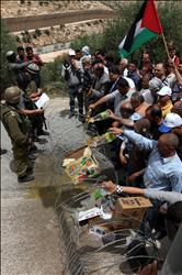 فلسطينيون يتلفون بضائع إسرائيلية خلال تظاهرة ضد الاستيطان في قرية بيت جالا قرب بيت لحم في الضفة الغربية أمس