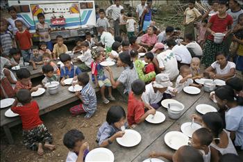 أطفال مشردون يتناولون وجبة جماعية قرب كوندانغون أمس 