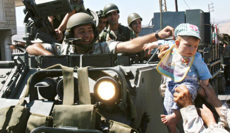 جندي لبناني يلاعب طفلاً لدى دخول الجيش إلى بلدة حولا 