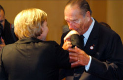 الرئيس الفرنسي جاك شيراك يقبل ميركل في هلسنكي أمس 
