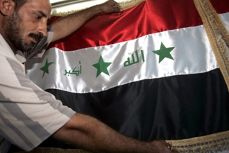 بائع يعرض العلم العراقي الحالي في محل ببغداد 