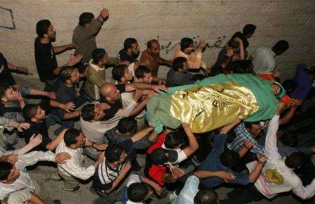 فلسطينيون يحملون جثمان صبي فلسطيني قتلته القوات الاسرائيلية رميا بالرصاص بالخليل 