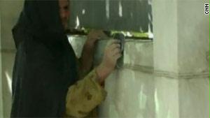 سيدة أفغانية تعمل على صبغ أحد الجدران
