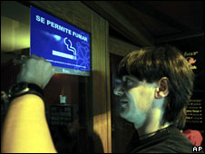 عامل في حانة اسبانية يزيل يافطة كتب عليها "التدخين مسموح هنا"