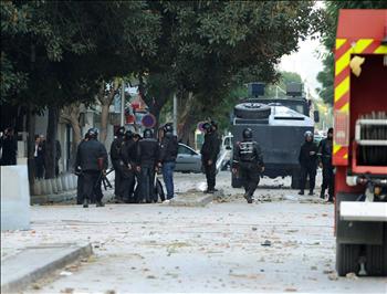 عناصر من مكافحة الشغب تحيط بشاب خلال تظاهرات في العاصمة تونس أمس