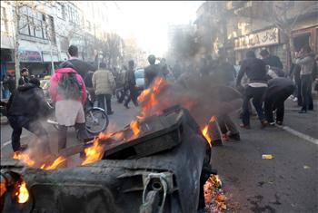 إيرانيون يحرقون حاوية نفايات خلال تظاهرات في طهران أمس