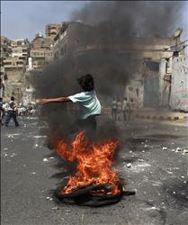 فتى يمني يقفز فوق اطار مشتعل خلال تظاهرة تطالب بتنحي صالح في تعز امس (رويترز) 