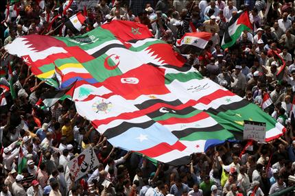 مصريون يحملون أعلام الدول العربية في ميدان التحرير أمس (أ ف ب) 