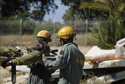 جنديان إسرائيليان خلال تدريبات في جنوب إسرائيل أمس على إنقاذ محاصرين من مبنى دُمر بصاروخ (أ ف ب) 