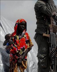 صومالية تحمل طفلها قرب جندي في مقديشو امس حيث اقيم مخيم لمساعدة المتضررين من الجفاف والمجاعة (ا ف ب) 
