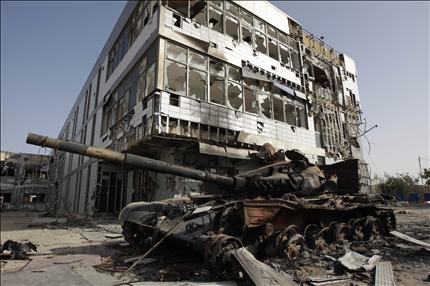 دبابة مدمرة أمام مستشفى في مدينة مصراتة أمس (رويترز) 