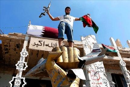 علم قطر فوق «بيت الصمود» في مجمع باب العزيزية في طرابلس غداة سيطرة الثوار الليبيين عليه («السفير») 
