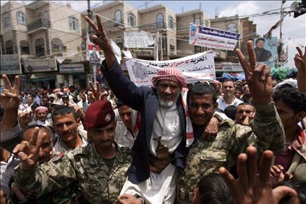 جنديان يمنيان يحملان شيخاً خلال تظاهرة في صنعاء للمطالبة برحيل صالح امس (ا ف ب) 