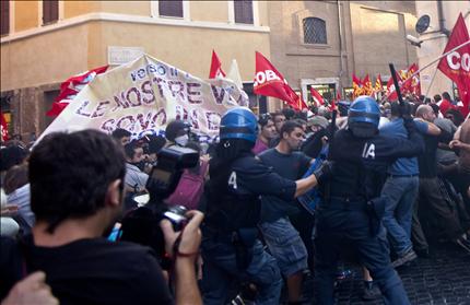 مواجهات بين متظاهرين ضد خطة التقشف الحكومية وشرطة مكافحة الشغب في روما أمس (أ ب أ) 
