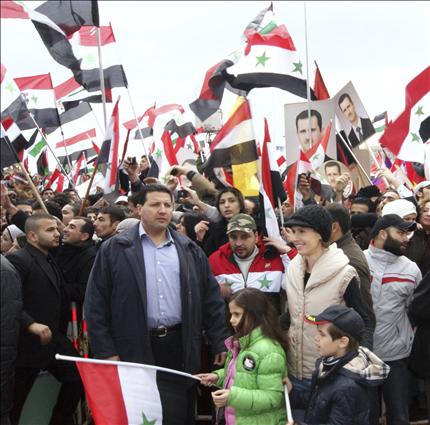 أسماء الأسد وابنها كريم وابنتها زين خلال تظاهرة دعم للأسد ظهر فيها الرئيس في دمشق أمس (رويترز) 