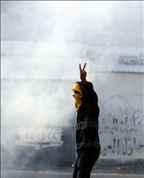 شاب بحريني يرفع شارة النصر خلال اشتباكات مع الشرطة في قرية غرب المنامة أمس (أ ب) 