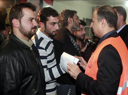 مراقب عربي يتحدث إلى سوريين بعد الإفراج عنهم من سجن عدرا قرب دمشق أمس (أ ب أ) 