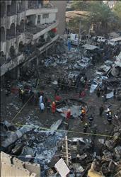 عراقيون يتفقدون الدمار جراء انفجار سيارة في حي الكرادة في بغداد أمس (أ ب) 