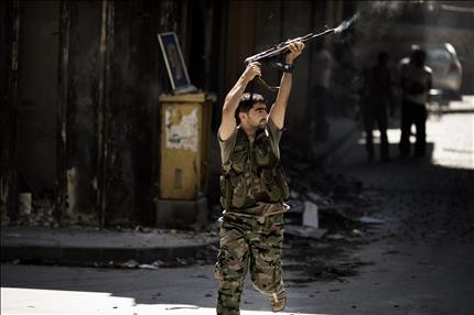 مسلح سوري يطلق النار على القوات النظامية في حلب أمس (أ ف ب) 