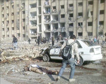 طالب سوري يسير قرب جثة أحد قتلى الهجوم على جامعة حلب أمس (أ ف ب) 