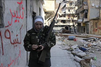  غيفارا، مديرة سابقة لمدرسة، والمتزوجة من «قيادي في كتيبة الوعد» تحمل بندقيتها خلال اشتباكات مع القوات السورية في حلب أمس الأول (رويترز) 