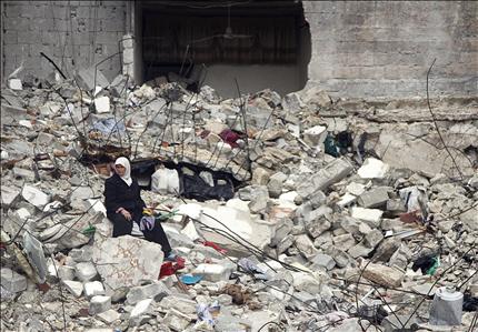 امرأة تجلس بين حطام منزلها في حي الانصاري في حلب امس الاول (ا ب) 