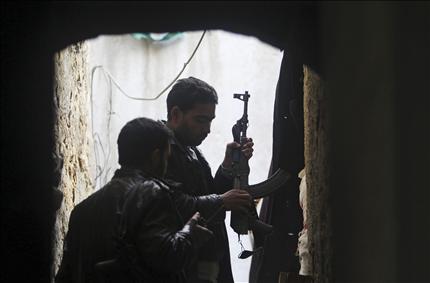 مسلحان خلال الاشتباكات مع القوات السورية في المدينة القديمة في حلب امس (رويترز) 