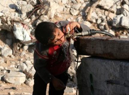 فتى فلسطيني يشرب الماء من حنفية قرب منزل مهدّم (عن «الانترنت») 