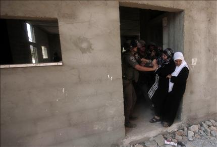 فلسطينيتان تقاومان محاولة جنود الاحتلال إخراجهما من منزلهما قبل هدمه في قرية حارس امس (أ ف ب) 