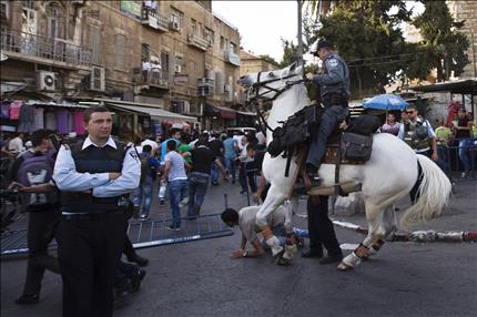 جندي إسرائيلي يعتدي بحصانه على المتظاهرين الفلسطينيين خلال اشتباكات في القدس العتيقة أمس (رويترز) 
