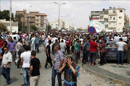 ليبيون يحتشدون حول موقع التفجير في مدينة بنغازي أمس (أ ف ب) 