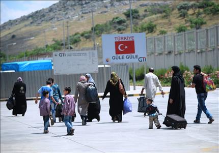 لاجئون سوريون على معبر جيلفيغوزي التركي الحدودي مع سوريا خلال عودتهم الى بلادهم امس (ا ف ب) 