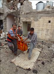 عراقيون ينقلون جثة أحد قتلى التفجيرات في مدينة كركوك أمس (أ ف ب) 
