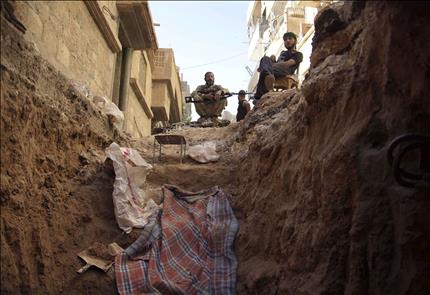 مسلحون سوريون قرب أحد الأنفاق في دير الزور أمس الأول (رويترز) 