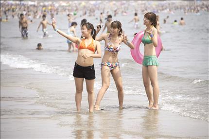 يابانيات يلتقطن الصور على شاطئ بحر كاماكورا في جنوب غرب العاصمة طوكيو أمس (ا ب ا) 