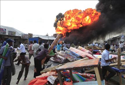 صوماليون يحاولون انقاذ بضائعهم بعد انفجار محطة وقود في مقديشو امس (رويترز) 