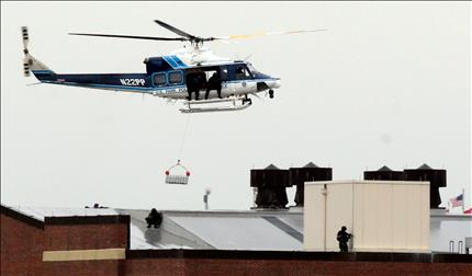 طوافة تنقل قناصة للانتشار على أسطح أحد أبنية القاعدة في واشنطن أمس (أ ف ب)
