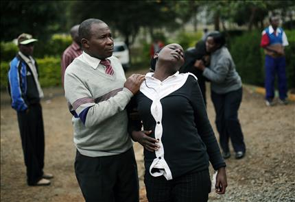 أقرباء الضحية موتيندا موسانغو (48 عاماً) يبكونه بعد التعرف على جثته في مستشفى نيروبي أمس (أ ب) 