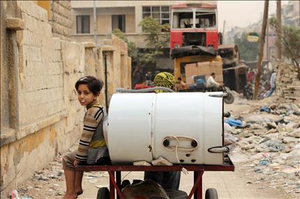 طفلة تجلس في عربة خلال فرارها مع والدها من حلب امس (ا ف ب) 