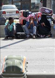 عمال أجانب ينتظرون نقلهم إلى مراكز متخصصة قبل ترحيلهم إلى بلادهم في الرياض أمس (أ ف ب) 