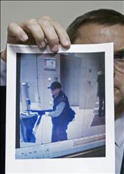 رئيس الشرطة القضائية كريستيان فلايش يحمل صورة المشتبه به في اقتحام صحيفة "ليبراسيون"أمس، خلال مهاجمته مكاتب قناة "بي.إف.إم. تي في" منذ أيام (ا ب ا) 