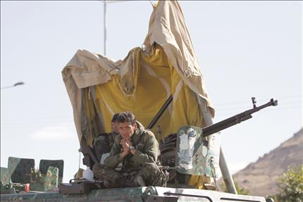 جندي يمني يجلس فوق آلية عسكرية قرب السفارة البريطانية في صنعاء أمس (رويترز)