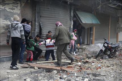 سوريون يفرون من موقع تعرض لغارة جوية في دوما في ريف دمشق امس (رويترز)