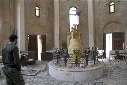 مسلح داخل كنيسة ارمنية مدمرة في دير الزور (رويترز)