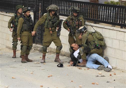 جنود الاحتلال الإسرائيلي يعتقلون فلسطينياً خلال تظاهرة ضد الاستيطان في الضفة الغربية أمس (ا ف ب)