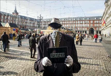 مجسم رجل يقف حاملاً جهاز «آيباد» يظهر على شاشته تاريخ 12:12:12 في بلاسا مايور في العاصمة الاسبانية مدريد أمس (رويترز) 