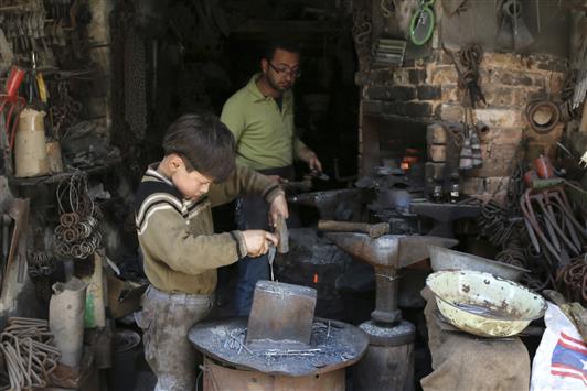 طفل يعمل في محل للحدادة في المدينة القديمة في حلب امس (رويترز)