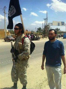 مسلح من 'داعش" في أحد شوارع القورية حاملاً راية تنظيمه