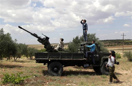 مسلحون على شاحنة عليها مضاد للطيران في معرة النعمان في ريف ادلب امس (رويترز)